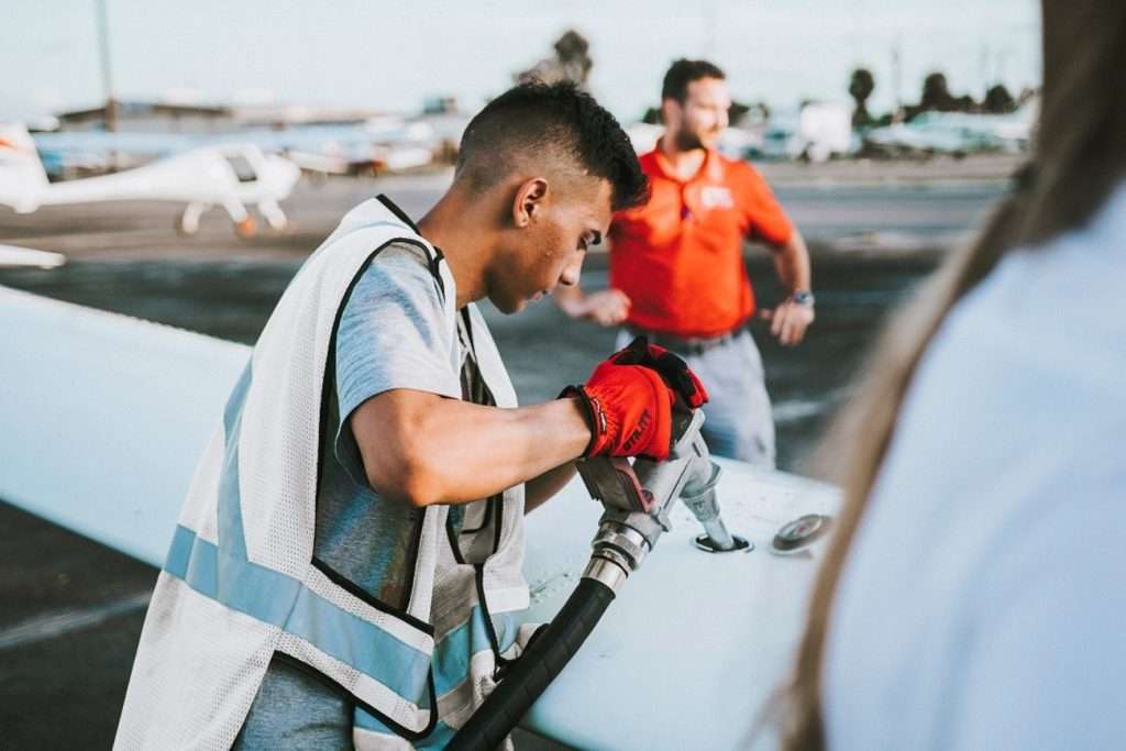 Private jets playing a role in fighting climate change. Private jet being refueled with sustainable aviation fuel (SAF) at the airport by FBO.